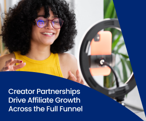 A creator with curly hair and glasses smiles and talks to her audience using her phone that's surrounded by a ring light.